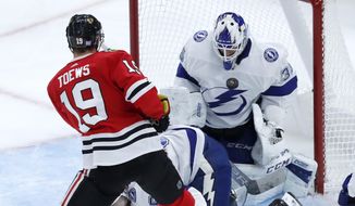 Tampa Bay Lightning goaltender Curtis McElhinney (35) makes a chest save on a shot by Chicago Blackhawks&#39; Jonathan Toews during the second period of an NHL hockey game Thursday, Nov. 21, 2019, in Chicago. (AP Photo/Charles Rex Arbogast)