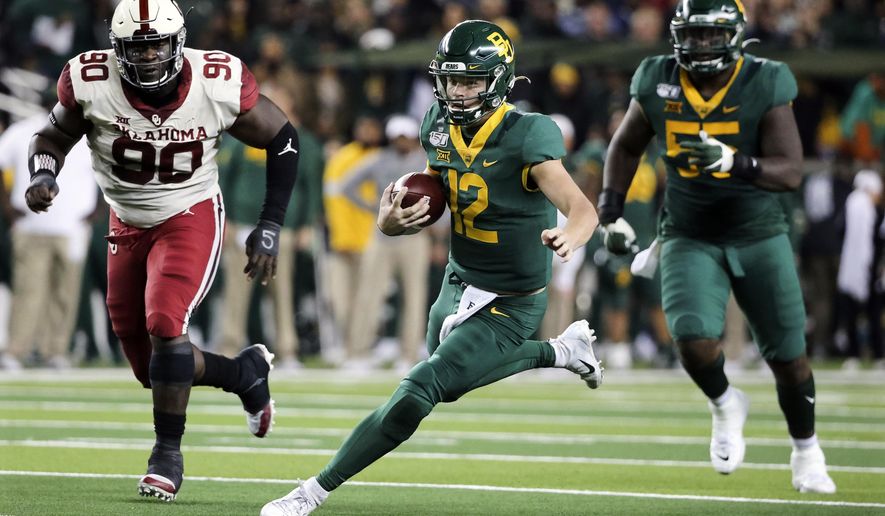 Baylor quarterback Charlie Brewer (12) carries the ball as he is chased by Oklahoma defensive lineman Neville Gallimore (90) during the first half of an NCAA college football game in Waco, Texas, Saturday, Nov. 16, 2019. (AP Photo/Ray Carlin)
