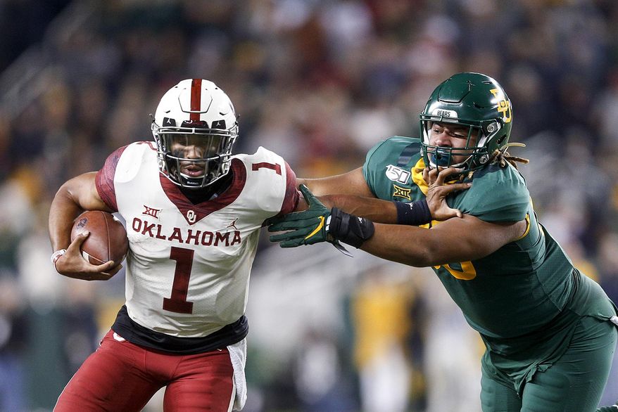 Oklahoma quarterback Jalen Hurts (1) stiff arms Baylor defensive tackle TJ Franklin (90) during an NCAA college football game, Saturday, Nov. 16, 2019, in Waco, Texas. Oklahoma won 34-31. (Ian Maule/Tulsa World via AP)
