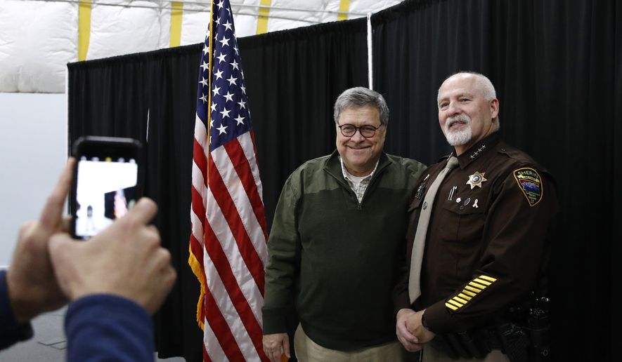 Attorney General William Barr poses for a photo with Sheriff Donald Bell of Lake County, Mont., after speaking at a law enforcement roundtable at the Flathead County Sheriff's Posse in Evergreen, Mont., Friday, Nov. 22, 2019. (AP Photo/Patrick Semansky) **FILE**