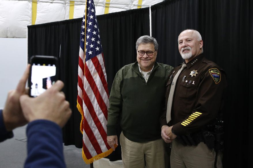 Attorney General William Barr poses for a photo with Sheriff Donald Bell of Lake County, Mont., after speaking at a law enforcement roundtable at the Flathead County Sheriff's Posse in Evergreen, Mont., Friday, Nov. 22, 2019. (AP Photo/Patrick Semansky) **FILE**
