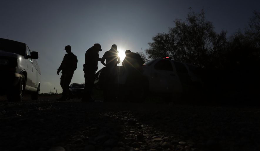 FILE - In this Nov. 6, 2019 file photo, Border Patrol agents apprehend a man thought to have entered the country illegally, near McAllen, Texas, along the U.S.-Mexico border. Immigration authorities are starting to ship asylum seekers who cross the border through Arizona to Texas, where they can be sent to Mexico to await their court hearings in the U.S. The government said its highly criticized program known colloquially as Remain in Mexico is now in effect all across the southwestern border. (AP Photo/Eric Gay, File)