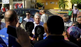 FILE - In this Nov. 14, 2019 file photo, Cuba&#39;s President Miguel Diaz-Canel, center, visits with residents after arriving in Caimanera, Cuba. A new decree approved by Diaz-Canel Oct. 8 and made public Monday, Nov. 18, 2019, says prosecutors can approve eavesdropping and surveillance of any form of communication, without consulting a judge as required in many other Latin American countries.  (AP Photo/Ismael Francisco, File)