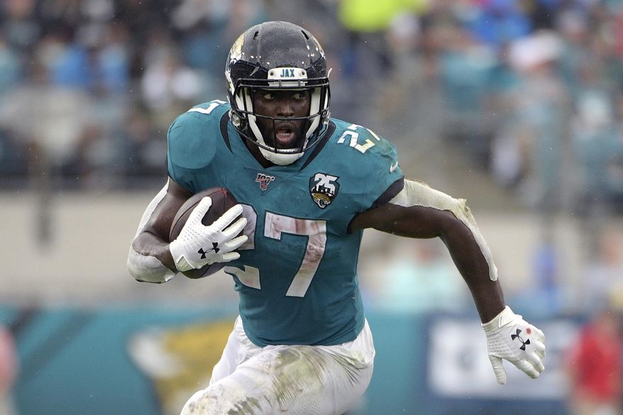 FILE - In this Oct. 27, 2019, file photo, Jacksonville Jaguars running back Leonard Fournette (27) rushes for yardage against the New York Jets during the first half of an NFL football game, in Jacksonville, Fla. Fournette had a series of meetings and calls this week after carrying the ball a season-low eight times in a 20-point loss to Indianapolis. The most notable of them was chatting with 1981 Heisman Trophy winner and retired Oakland Raiders star Marcus Allen, who told the third-year pro about his experience having to play fullback and share a backfield with fellow Heisman winner Bo Jackson more than 30 years ago. “His situation was harder than mine,” said Fournette, who first met Allen during a recruiting visit to USC while he was in high school.(AP Photo/Phelan M. Ebenhack, File)