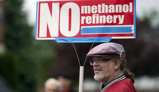 FILE - In this 2017 file photo, Mark Keely, of Kalama, Wash., stands with other protesters outside the Washington Department of Ecology&#39;s Vancouver field office in 2017. Keely and others were demonstrating against the proposed methanol refinery that could be built in Kalama. The department dealt the project a setback on Friday, Nov. 22, 2019, saying it could not proceed without further environmental review of its greenhouse gas emissions. (Amanda Cowan/The Columbian via AP, File)
