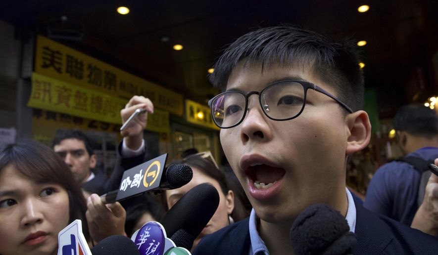 Pro-democracy activist Joshua Wong speaks to journalists outside of a polling place in Hong Kong, Sunday, Nov. 24, 2019. Voting was underway Sunday in Hong Kong elections that have become a barometer of public support for anti-government protests now in their sixth month. (AP Photo/Ng Han Guan)
