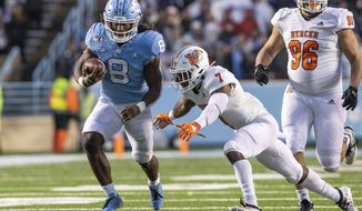 North Carolina&#39;s Michael Carter (8) carries the ball as Mercer&#39;s Eric Jackson (7) attempts a tackle during an NCAA college football game in Chapel Hill, N.C., Saturday, Nov. 23, 2019. (AP Photo/Ben McKeown)