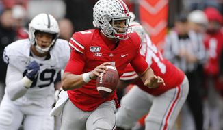 Ohio State quarterback Justin Fields, right, looks for an open receiver as Penn State defensive lineman Yetur Gross-Matos chases him during the second half of an NCAA college football game Saturday, Nov. 23, 2019, in Columbus, Ohio. Ohio State beat Penn State 28-17. (AP Photo/Jay LaPrete)
