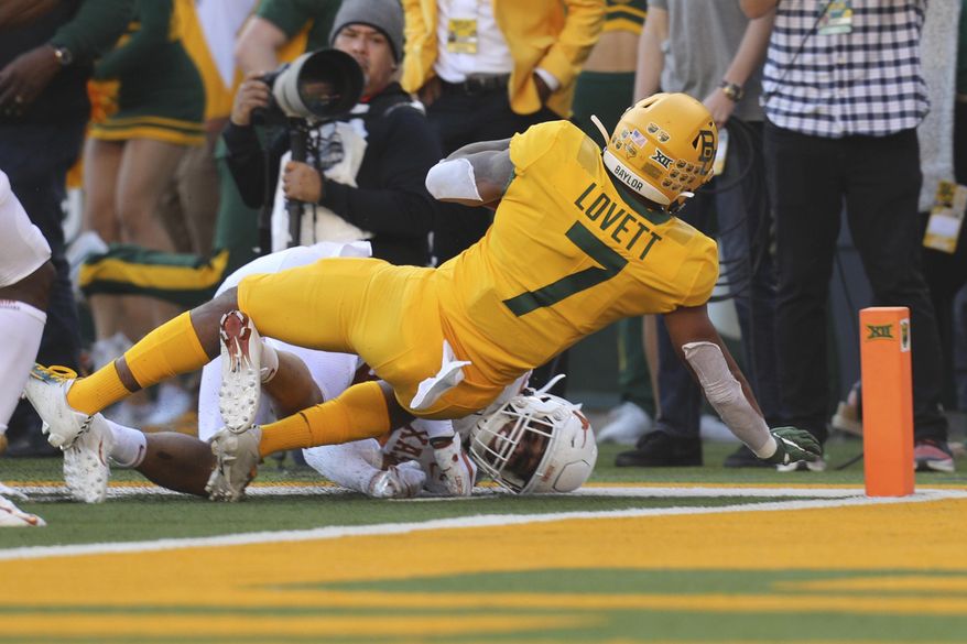 Baylor running back John Lovett (7) falls backward into the end zone for a touchdown against Texas in an NCAA college football game Saturday, Nov. 23, 2019, in Waco, Texas. (AP Photo/Richard W. Rodriguez)