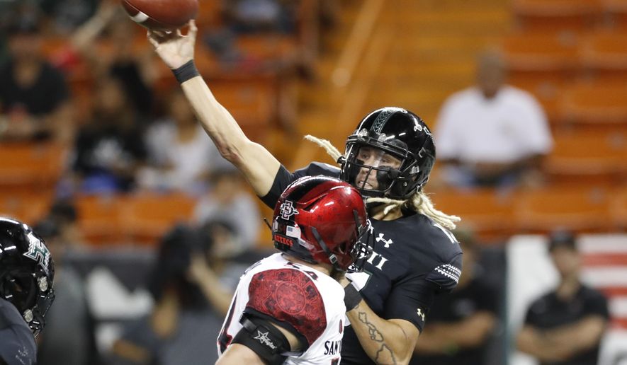 Hawaii quarterback Cole McDonald (13) throws a pass next to San Diego State linebacker Caden McDonald during the first half of an NCAA college football game Saturday, Nov. 23, 2019, in Honolulu. (AP Photo/Marco Garcia)