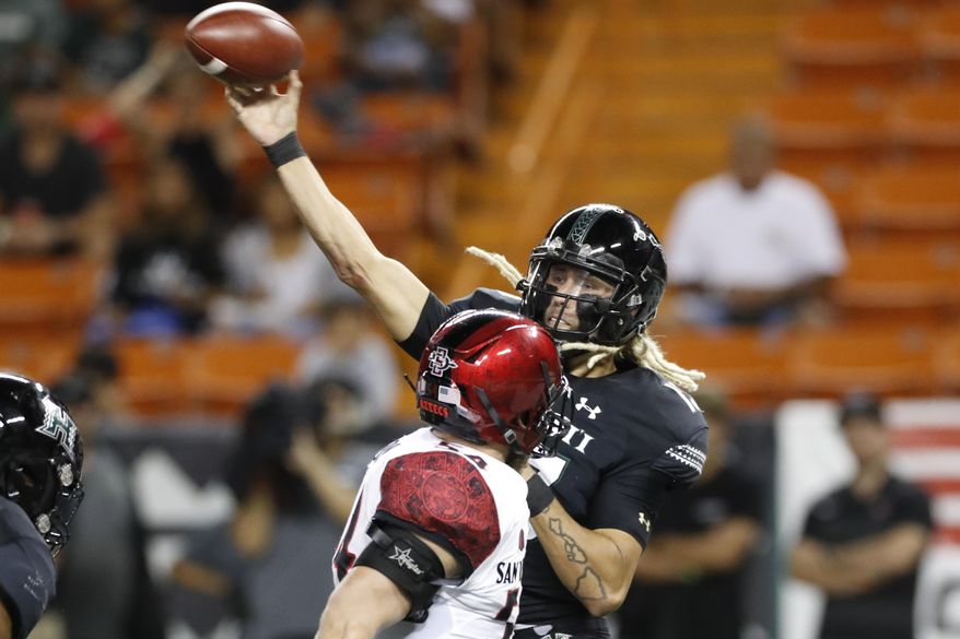 Hawaii quarterback Cole McDonald (13) throws a pass next to San Diego State linebacker Caden McDonald during the first half of an NCAA college football game Saturday, Nov. 23, 2019, in Honolulu. (AP Photo/Marco Garcia)