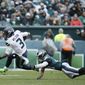 Seattle Seahawks&#x27; Russell Wilson, left, tries to avoid Philadelphia Eagles&#x27; Rodney McLeod during the first half of an NFL football game, Sunday, Nov. 24, 2019, in Philadelphia. (AP Photo/Michael Perez)
