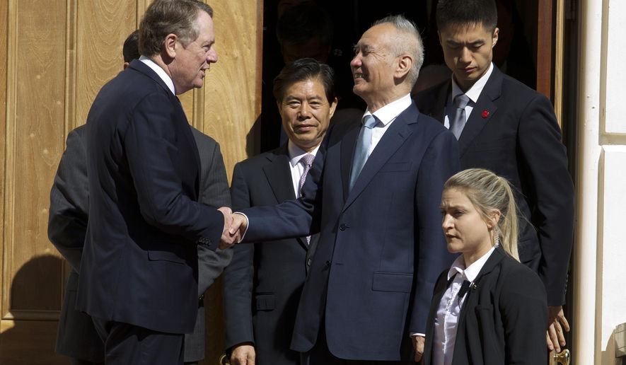 FILE - In this Oct. 11, 2019, file photo, Chinese Vice Premier Liu He, center right, shakes hands with U.S. Trade Representative Robert Lighthizer, center left, after a minister-level trade meeting at the Office of the United States Trade Representative in Washington. China’s Commerce Ministry says the lead envoys in trade talks between China and the U.S. spoke on the phone and agreed to continue to work toward a preliminary agreement for resolving their tariff war. (AP Photo/Jose Luis Magana, File)