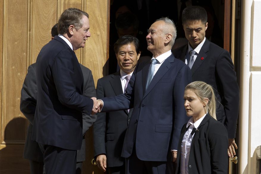 FILE - In this Oct. 11, 2019, file photo, Chinese Vice Premier Liu He, center right, shakes hands with U.S. Trade Representative Robert Lighthizer, center left, after a minister-level trade meeting at the Office of the United States Trade Representative in Washington. China’s Commerce Ministry says the lead envoys in trade talks between China and the U.S. spoke on the phone and agreed to continue to work toward a preliminary agreement for resolving their tariff war. (AP Photo/Jose Luis Magana, File)