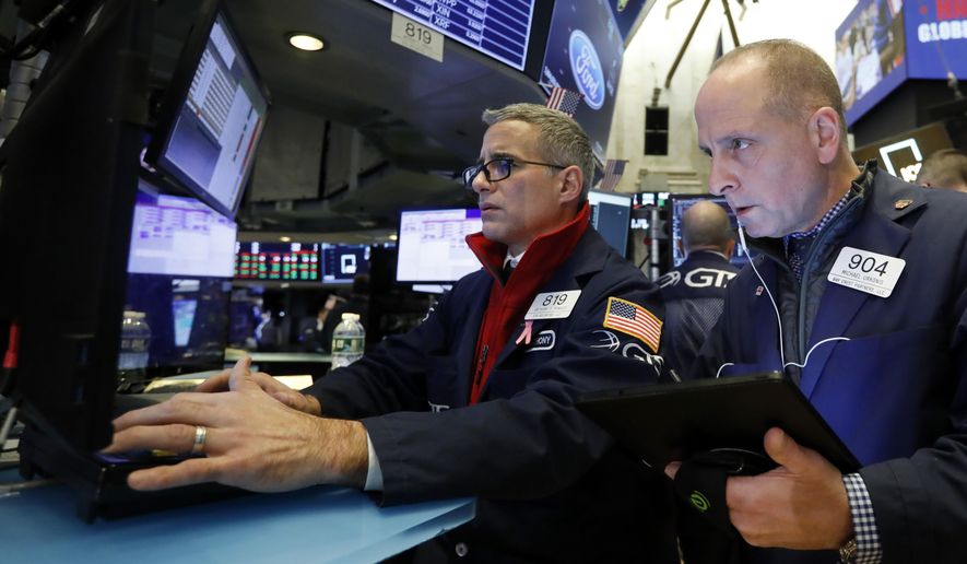 FILE - In this Nov. 20, 2019, file photo specialist Anthony Rinaldi, left, and trader Michael Urkonis work on the floor of the New York Stock Exchange. The U.S. stock market opens at 9:30 a.m. EST on Monday, Nov 25. (AP Photo/Richard Drew, File)