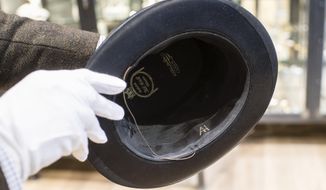 In this Wednesday, Nov. 20, 2019, photo, a person shows a personal top hat of Adolf Hitler with the initials &#x27;AH&#x27; prior to an auction in Grasbrunn near Munich, Germany. A Geneva businessman says he has purchased Adolf Hitler&#x27;s top hat and other Nazi memorabilia to keep them out of the hands of neo-Nazis and will donate them to a Jewish group. (Matthias Balk/dpa via AP)