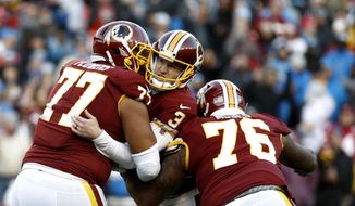 Washington Redskins kicker Dustin Hopkins, center, is mobbed by offensive guard Ereck Flowers (77) and offensive tackle Morgan Moses (76) after kicking the eventual game-winning field goal in the final seconds of the second half of an NFL football game against the Detroit Lions, Sunday, Nov. 24, 2019, in Landover, Md. The Redskins won 19-16. (AP Photo/Patrick Semansky) ** FILE **