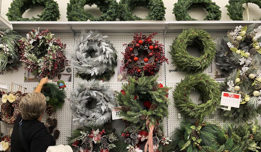FILE - In this Nov. 9, 2019, file photo a woman looks through holiday wreathes on sale at a retail store during in Pembroke Pines, Fla. On Tuesday, Nov. 26, the Conference Board reports on U.S. consumer confidence for November. (AP Photo/Brynn Anderson, File)
