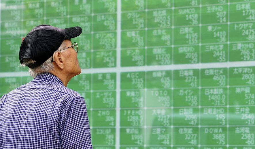 In this Oct. 3, 2019, photo, a man looks at an electronic stock board showing Japan's Nikkei 225 index at a securities firm in Tokyo. Asian shares were mostly higher Tuesday, Nov. 26, 2019 on optimism over U.S.-China trade talks, prompted by Beijing’s new guidelines for the protection of patents and copyrights. (AP Photo/Eugene Hoshiko)