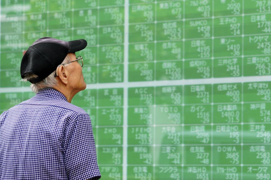 In this Oct. 3, 2019, photo, a man looks at an electronic stock board showing Japan's Nikkei 225 index at a securities firm in Tokyo. Asian shares were mostly higher Tuesday, Nov. 26, 2019 on optimism over U.S.-China trade talks, prompted by Beijing’s new guidelines for the protection of patents and copyrights. (AP Photo/Eugene Hoshiko)