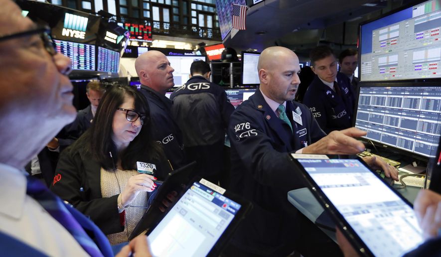 FILE - In this Nov. 20, 2019, file photo specialist Mario Picone, right, works with traders at his post on the floor of the New York Stock Exchange. The U.S. stock market opens at 9:30 a.m. EST on Tuesday, Nov 26. (AP Photo/Richard Drew, File)
