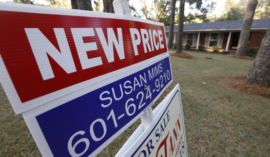 FILE - In this Sept. 25, 2019, file photo a sign indicating a new selling price for a house sits atop a realtor's sign in Jackson, Miss. On Tuesday, Nov. 26, the Standard & Poor's/Case-Shiller 20-city home price index for September is released. (AP Photo/Rogelio V. Solis, File)