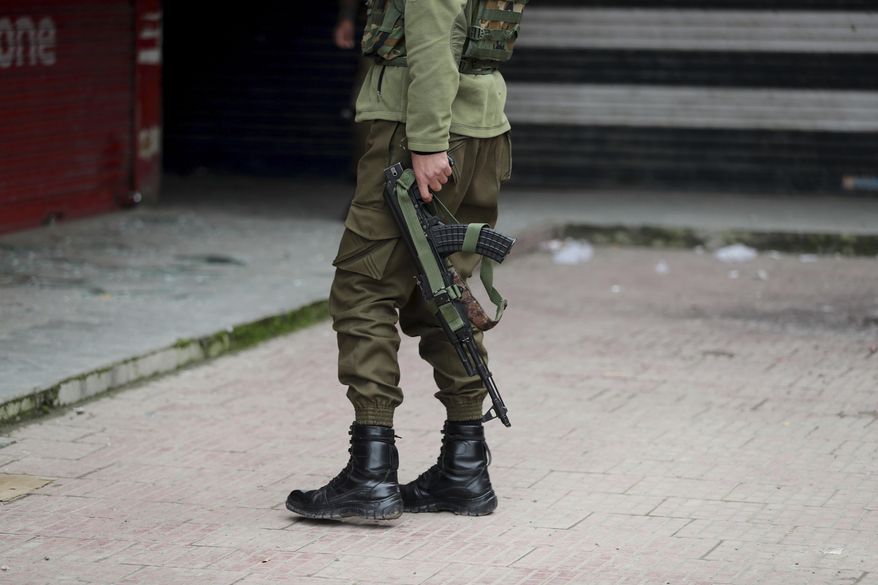 An Indian policeman inspects the site of an explosion at a market in Srinagar, Indian controlled Kashmir, Tuesday, Nov. 26, 2019. Police said at least three civilians were injured in an explosion outside a restaurant in Srinagar, the main city in the disputed region. (AP Photo/Mukhtar Khan)