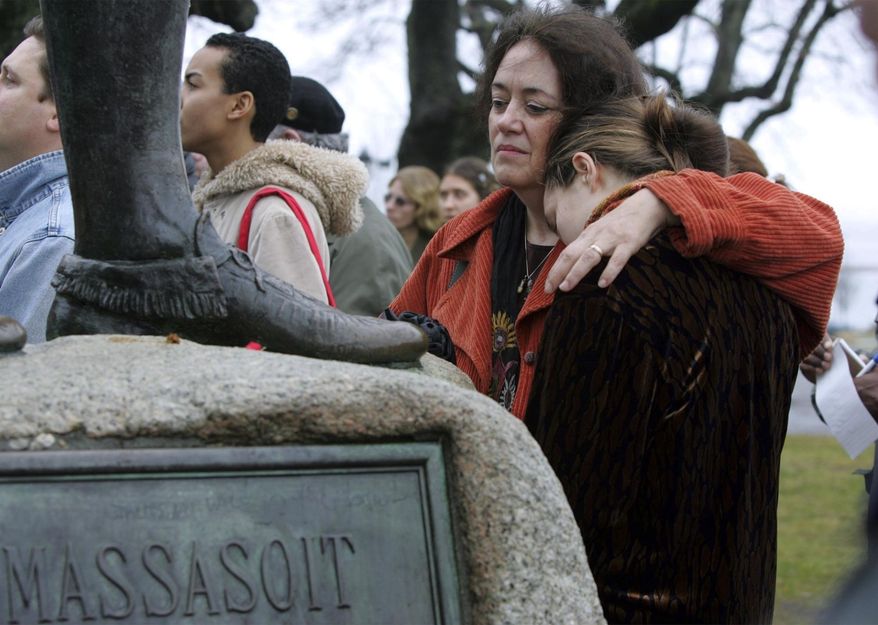 FILE - In this Nov. 25, 2004 file photo, Native American supporter Deborah Theodore, left, of Belmont, Mass., and her daughter, Sofia Theodore-Pierce stand together by the statue of Massasoit on Cole's Hill in Plymouth, Mass., during the 35th National Day of Mourning. United American Indians of New England held the first National Day of Mourning in 1970, and again plan to gather at noon on Thanksgiving Day, Thursday, Nov. 28, 2019. (AP Photo/Chitose Suzuki, File)