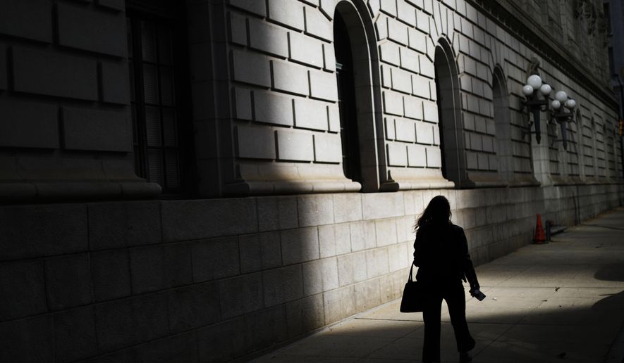 FILE - In this Dec. 3, 2018, file photo a pedestrian is silhouetted against a ray of sunlight hitting a downtown courthouse in Atlanta. Part of being an adult is acknowledging what you learned from your parents, and what you might have to learn for yourself. This is especially true when it comes to managing money (AP Photo/David Goldman, File)