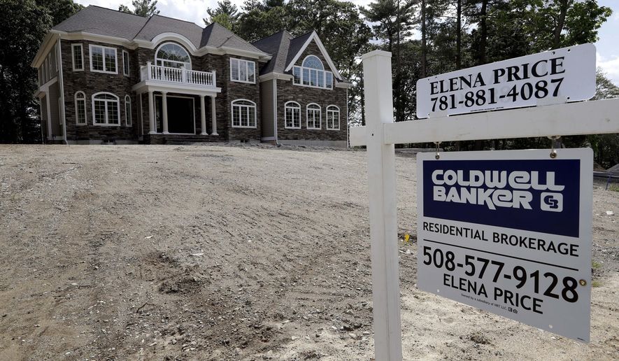 FILE - In this Sept. 3, 2019 file photo a sign rests in front of a newly constructed home, in Westwood, Mass. On Tuesday, Nov. 26, the Commerce Department reports on sales of new homes in October. (AP Photo/Steven Senne, File)