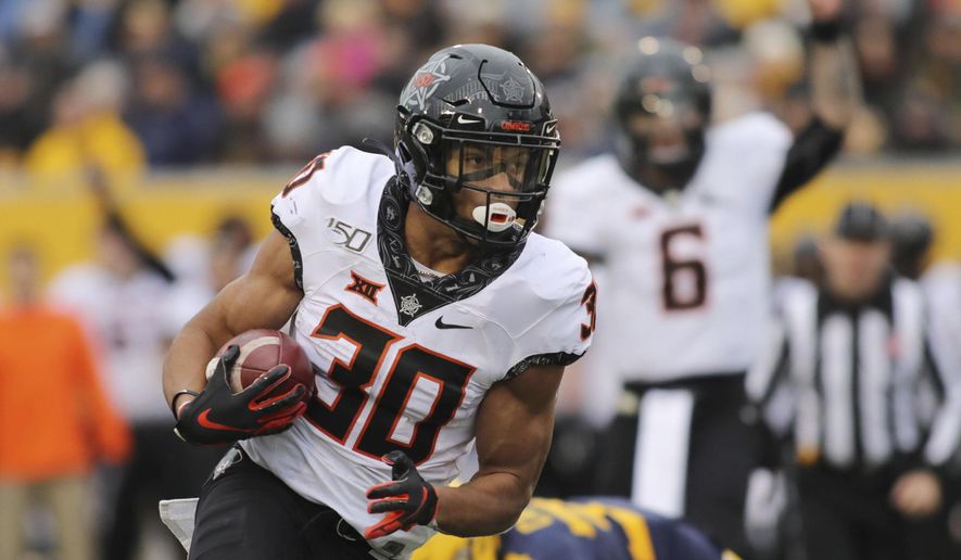 Oklahoma State's Chuba Hubbard (30) carries the ball during the second quarter of an NCAA college football game against West Virginia in Morgantown, W.Va., on Saturday, Nov. 23, 2019. (AP Photo/Chris Jackson)
