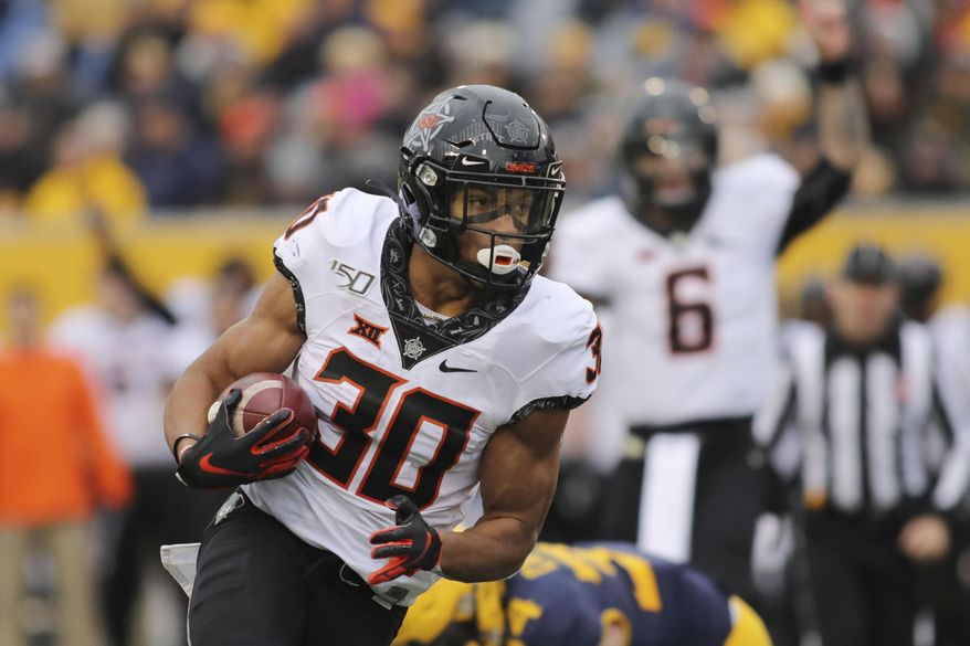 Oklahoma State's Chuba Hubbard (30) carries the ball during the second quarter of an NCAA college football game against West Virginia in Morgantown, W.Va., on Saturday, Nov. 23, 2019. (AP Photo/Chris Jackson)