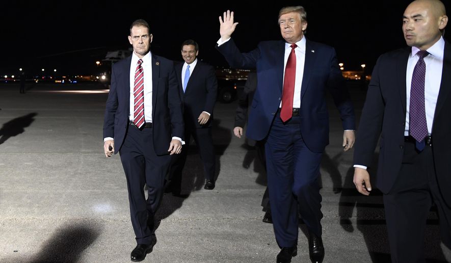 President Donald Trump walks to greet supporters as he arrives on Air Force One at Palm Beach International Airport, in West Palm Beach, Fla., Tuesday, Nov. 26, 2019. The Trumps are in Florida to spend the Thanksgiving holiday at their Mar-a-lago estate. (AP Photo/Susan Walsh)