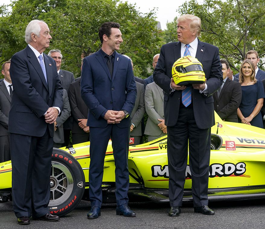 President Donald J. Trump is presented a racing helmet by race car driver Simon Pagenaud and Team Penske owner Roger Penske, left, as the 103rd Indianapolis 500 Champion Team and their race car are honored Monday, June 10, 2019, at the White House. (Official White House Photo by Tia Dufour)