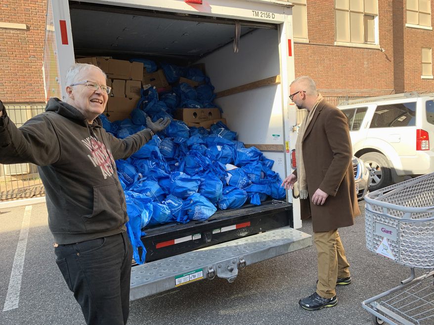 Mark Andersen (left) prepares to deliver a truckload of Thanksgiving turkeys to elderly residents in Northwest on Tuesday, Nov. 26, 2018. Mr. Andersen is the co-director of We Are Family, a nonprofit volunteer group. Photo by Sophie Kaplan / The Washington Times