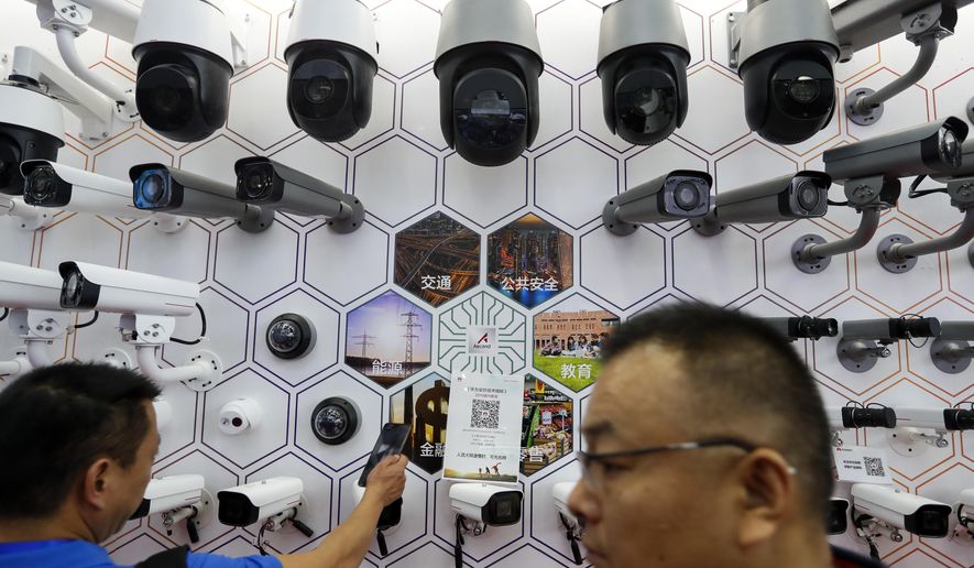 In this Tuesday, Oct. 29, 2019, photo, visitors look at the surveillance cameras and services provided by China&#x27;s telecoms equipment giant Huawei on display at the China Public Security Expo in Shenzhen, China&#x27;s Guangdong province. The U.S. Department of Commerce has proposed requiring case-by-case approvals of all purchases of telecommunications equipment in a move likely to hit major Chinese suppliers like Huawei. (AP Photo/Andy Wong)