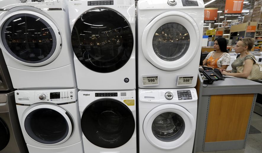 FILE - In this Sept. 23, 2019, file photo, clothes dryers, top, are stacked on top of washing machines at a Home Depot store location, in Boston. On Wednesday, Nov. 27, the Commerce Department releases its October report on durable goods. (AP Photo/Steven Senne, File)