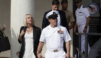 File - In this July 2, 2019, file photo, Navy Special Operations Chief Edward Gallagher, center, walks with his wife, Andrea Gallagher, as they leave a military court on Naval Base San Diego in San Diego. The acting Navy secretary has canceled a peer-review process for three Navy SEALs who supervised a fourth SEAL convicted of posing with a dead teenage prisoner in Iraq. Acting Navy Secretary Thomas Modly said Wednesday, Nov. 27, 2019, the case was becoming a distraction. The decision comes after President Donald Trump intervened in the case of Chief Petty Officer Gallagher. (AP Photo/Gregory Bull, File)
