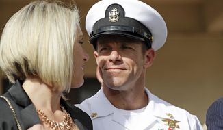 In this July 2, 2019, file photo, Navy Special Operations Chief Edward Gallagher, right, walks with his wife, Andrea Gallagher as they leave a military court on Naval Base San Diego, in San Diego. (AP Photo/Gregory Bull, File)