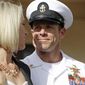 In this July 2, 2019, file photo, Navy Special Operations Chief Edward Gallagher, right, walks with his wife, Andrea Gallagher as they leave a military court on Naval Base San Diego, in San Diego. (AP Photo/Gregory Bull, File)