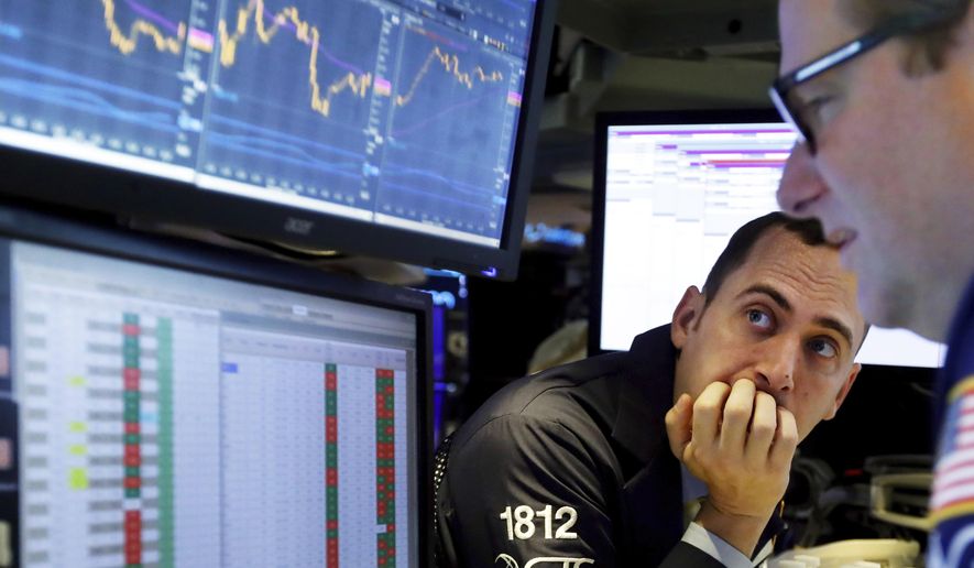 FILE - In this Nov. 14, 2019, file photo a pair of specialists work on the floor of the New York Stock Exchange. Corporate profits continued their yearlong slide during the third quarter and analysts expect another poor performance before things start improving. (AP Photo/Richard Drew, File)