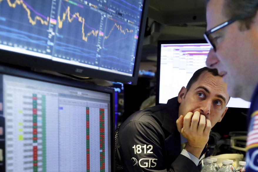 FILE - In this Nov. 14, 2019, file photo a pair of specialists work on the floor of the New York Stock Exchange. Corporate profits continued their yearlong slide during the third quarter and analysts expect another poor performance before things start improving. (AP Photo/Richard Drew, File)