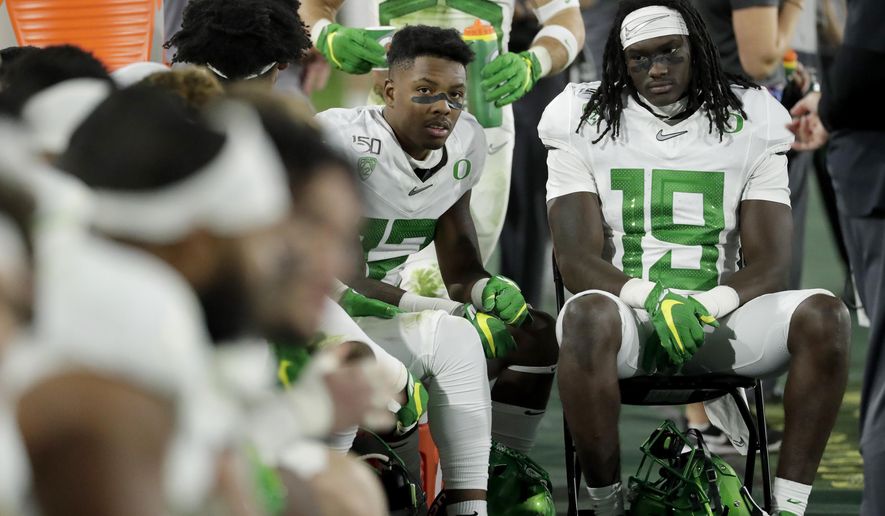 Oregon players sit on the bench during the second half of the team's NCAA college football game against Arizona State, Saturday, Nov. 23, 2019, in Tempe, Ariz. Arizona State won 31-28. (AP Photo/Matt York)