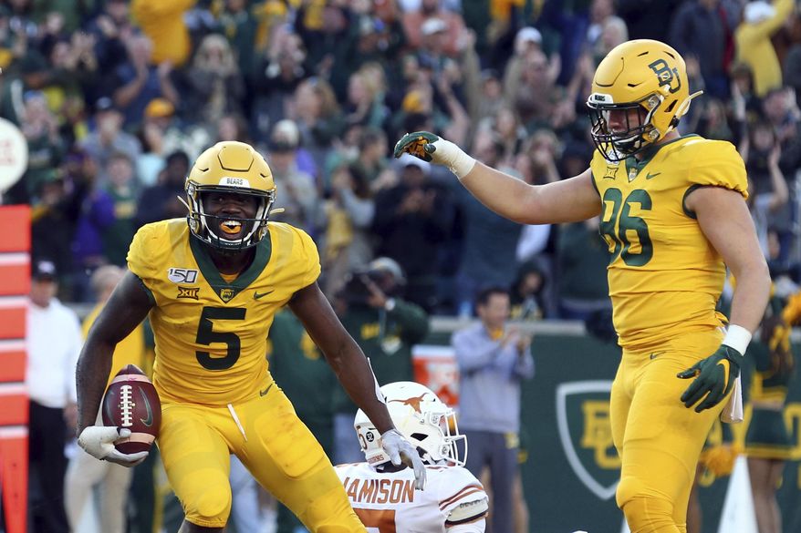 Baylor wide receiver Denzel Mims (5) and tight end Ben Sims (86) celebrate a third-quarter touchdown against Texas in an NCAA college football game Saturday, Nov. 23, 2019, in Waco, Texas. (AP Photo/Richard W. Rodriguez)