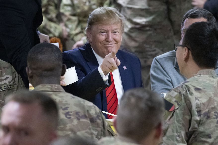 President Donald Trump points while eating during a surprise Thanksgiving Day visit to the troops, Thursday, Nov. 28, 2019, at Bagram Air Field, Afghanistan. (AP Photo/Alex Brandon)