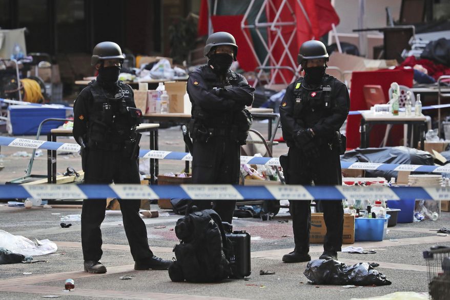 Bomb disposal police watch from a cordoned area as evidence is collected in a cordoned off area in the Polytechnic University campus in Hong Kong, Thursday, Nov. 28, 2019. Police safety teams Thursday began clearing a university that was a flashpoint for clashes with protesters, and an officer said any holdouts still hiding inside would not be immediately arrested. (AP Photo/Ng Han Guan)
