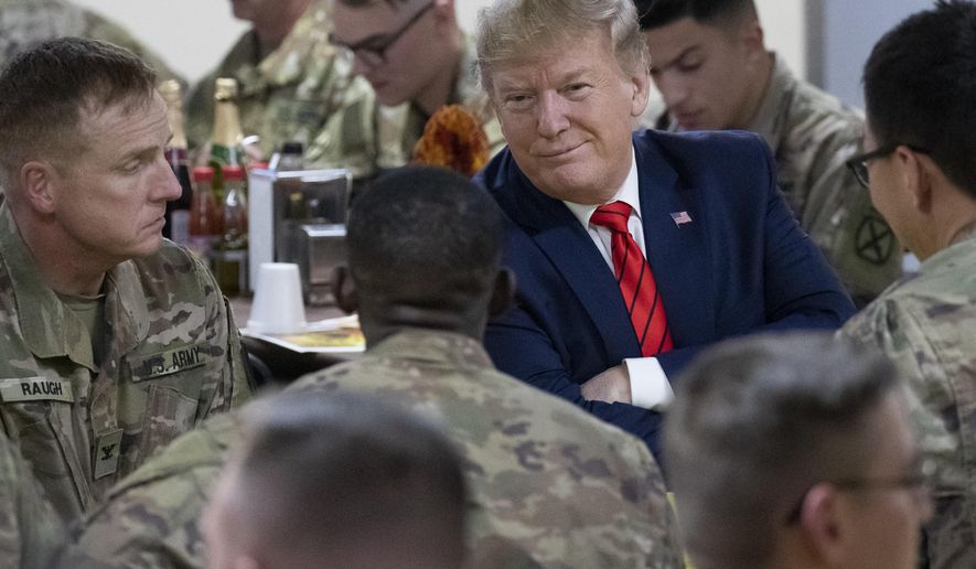 President Donald Trump smiles while sitting with the troops during a surprise Thanksgiving Day visit to the troops, Thursday, Nov. 28, 2019, at Bagram Air Field, Afghanistan. (AP Photo/Alex Brandon)