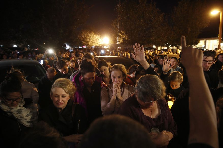 In this Nov. 8, 2018, file photo, people gather outside the Rivalry Roasters coffee shop for a vigil for Sean Adler in Simi Valley, Calif. Adler was killed in a shooting at the Borderline Bar & Grill in Thousand Oaks, Calif., on Nov. 7, 2018. The Southern California country-western bar where 12 people were killed in the shooting and gunbattle will reopen more than a year after the tragedy, the bar's owners say in a video posted Thursday, Nov. 28, 2019. (AP Photo/Jae C. Hong, File) **FILE**