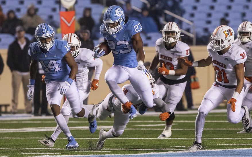 North Carolina's Josh Henderson (23) leaps to try to avoid a tackle from Mercer's Kendall Bohler (29) during the second half of an NCAA college football game in Chapel Hill, N.C., Saturday, Nov. 23, 2019. (AP Photo/Ben McKeown)