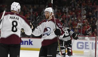 Colorado Avalanche&#39;s Cale Makar (8) celebrates with teammate J.T. Compher (37) after scoring during the first period of an NHL hockey game against the Chicago Blackhawks Friday, Nov. 29, 2019, in Chicago. (AP Photo/Paul Beaty)